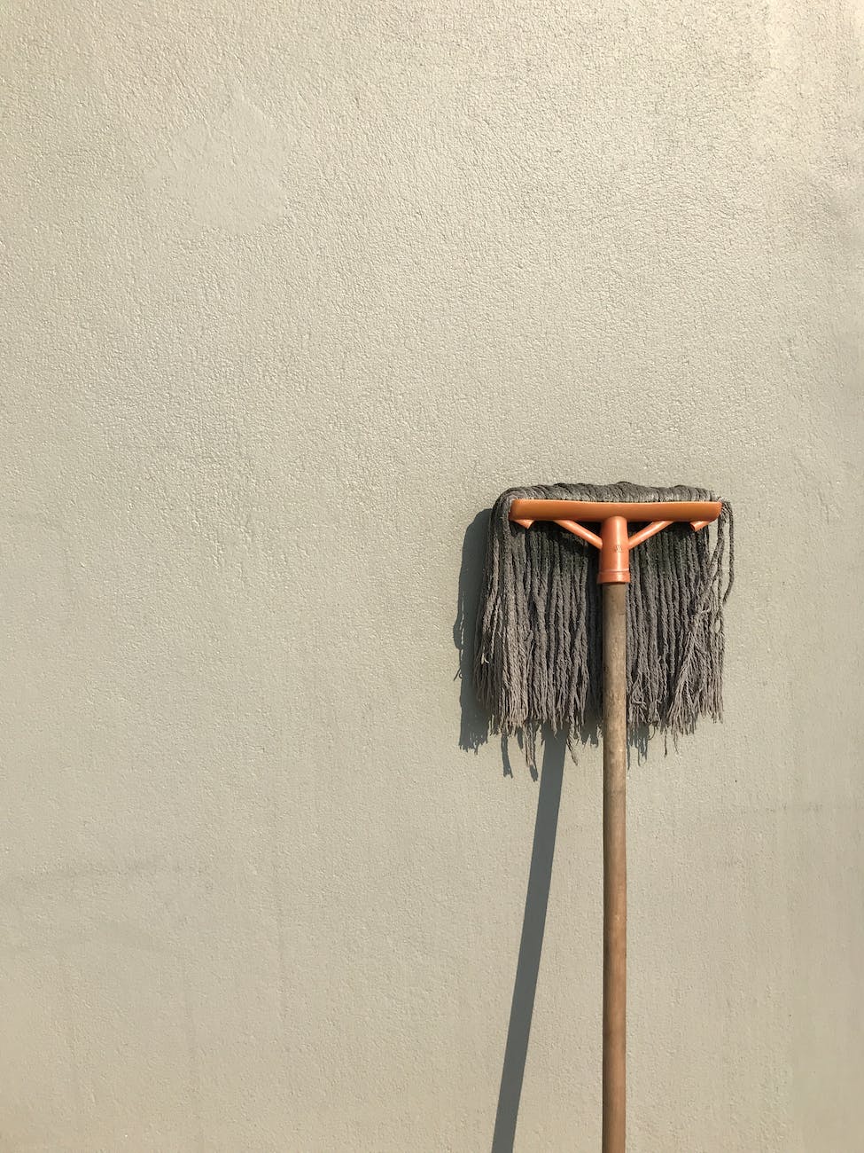 gray and brown floor mop on white wall